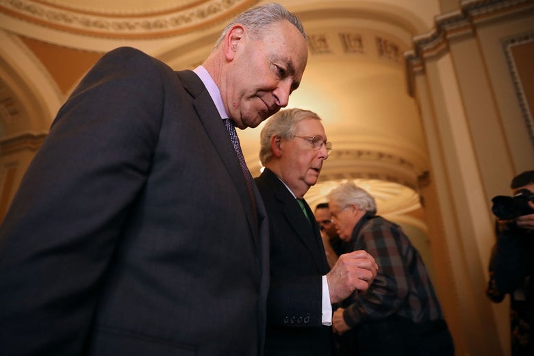 Schumer and McConnell walk side by side as McConnell speaks.